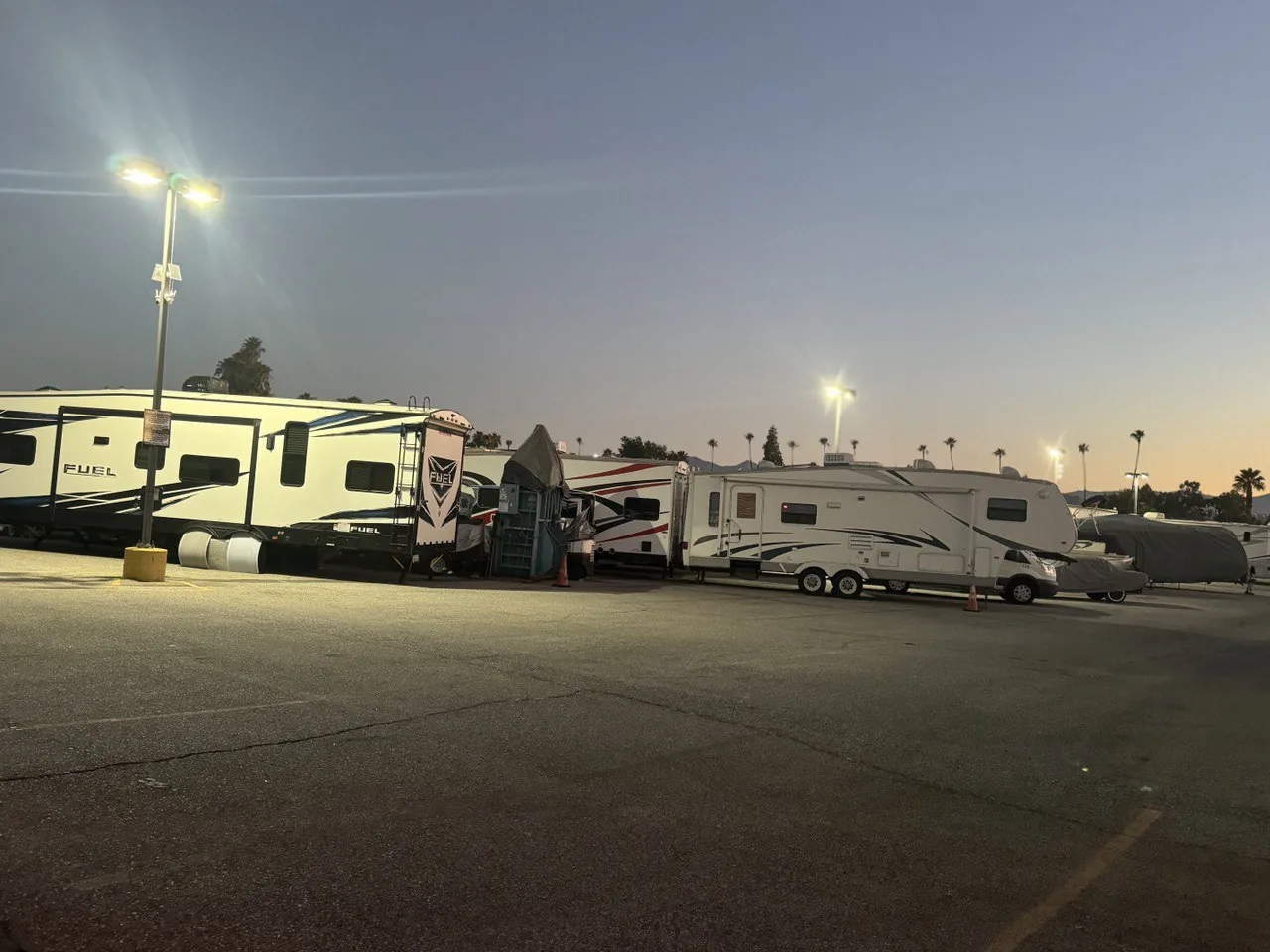 Circle C Storage lot at dusk, RVs lit by tall floodlights against a golden sunset sky